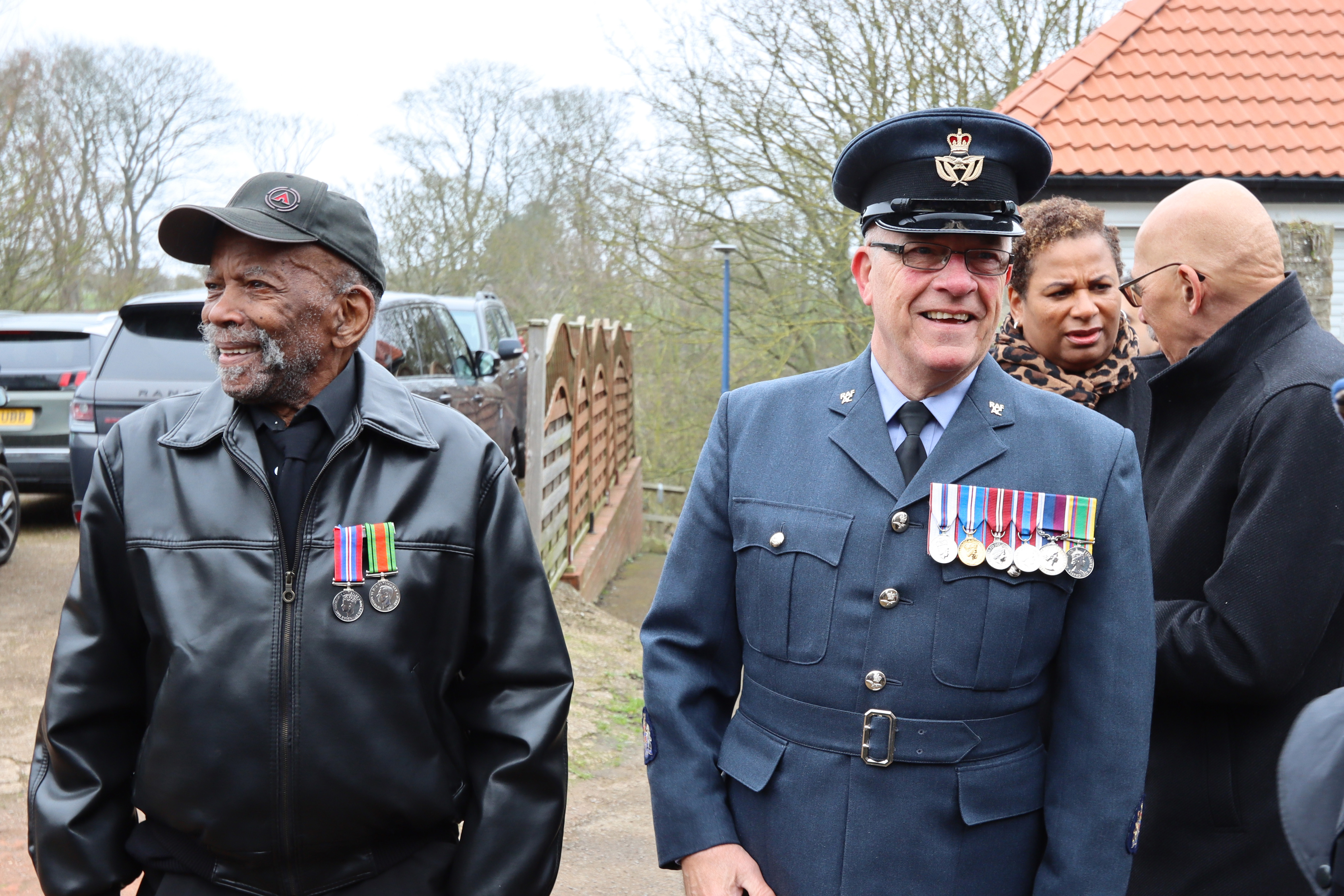 Image shows RAF personnel standing with civilians and veterans.